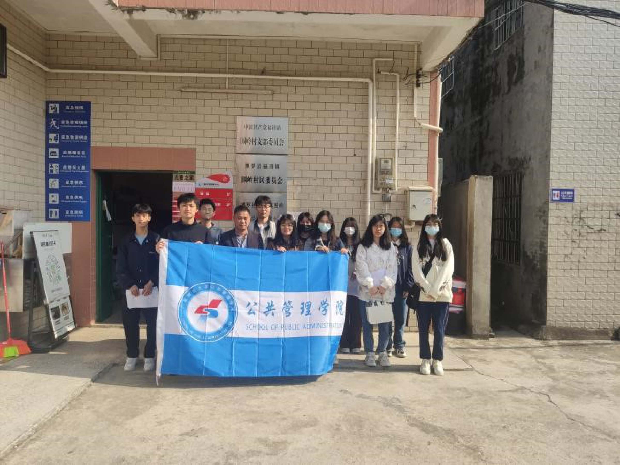 图为队员与村委在围岭村村委拍合照