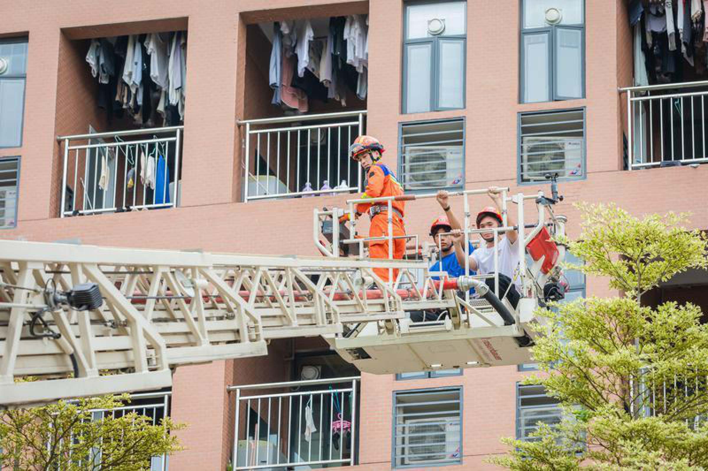 消防员使用云梯车转移被困在高层的学生。（摄影：王澍）