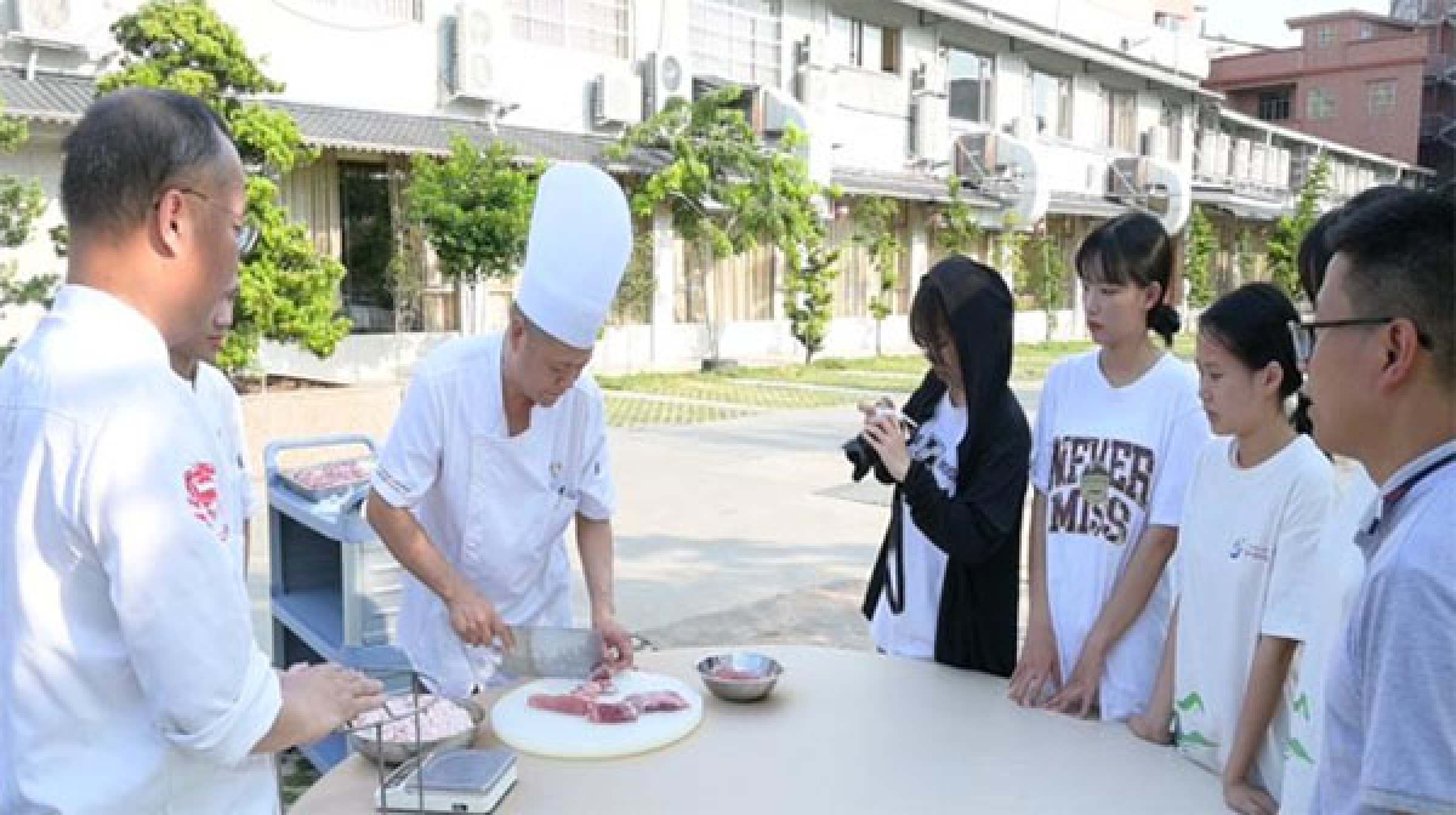 图为成员正在跟着师傅学做道滘肉丸。
