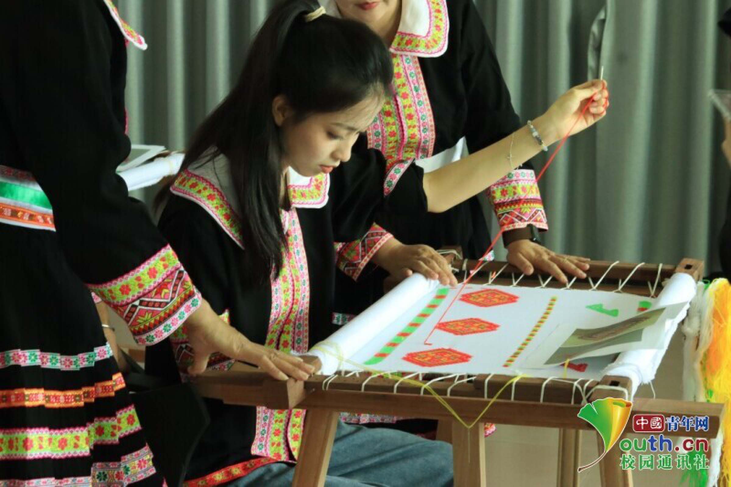 图为团队成员在文化传承人的指导下体验瑶绣，感受非遗文化。